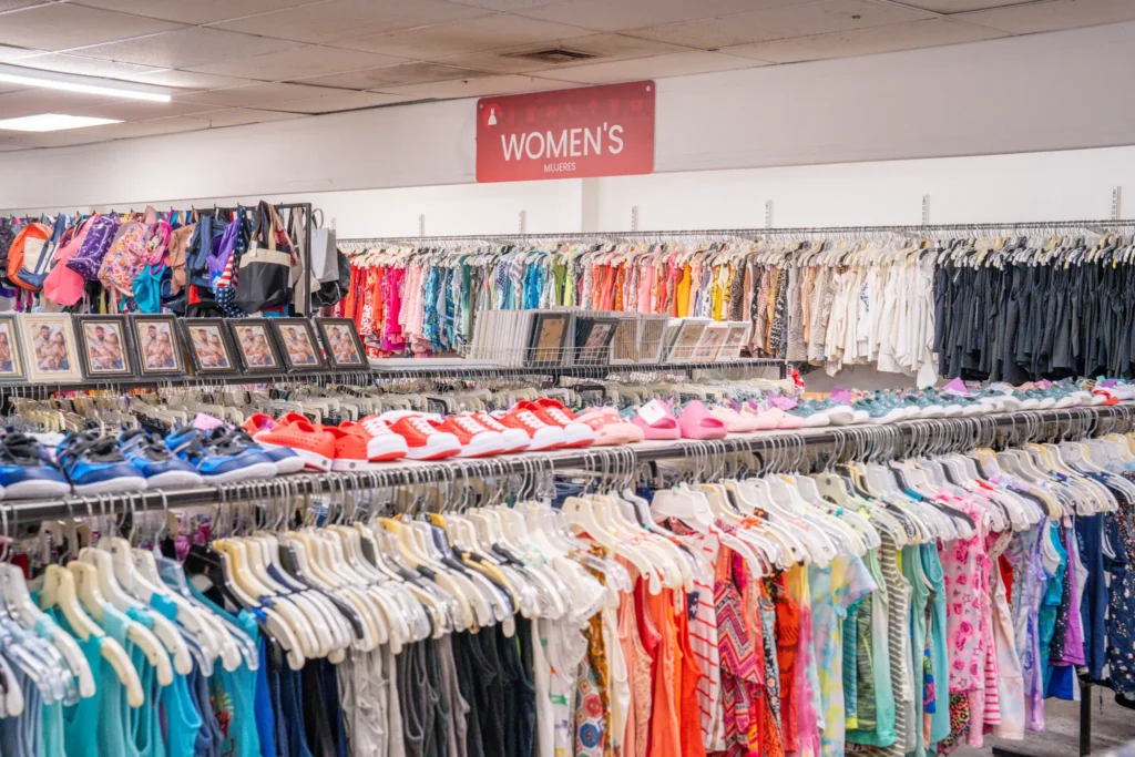Women’s clothing racks, shoes, handbags, and framed artwork inside the Value World Jensen thrift store.