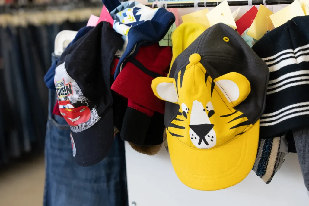 Colorful children’s hats and character caps, including tiger and race car designs, displayed inside Value World.
