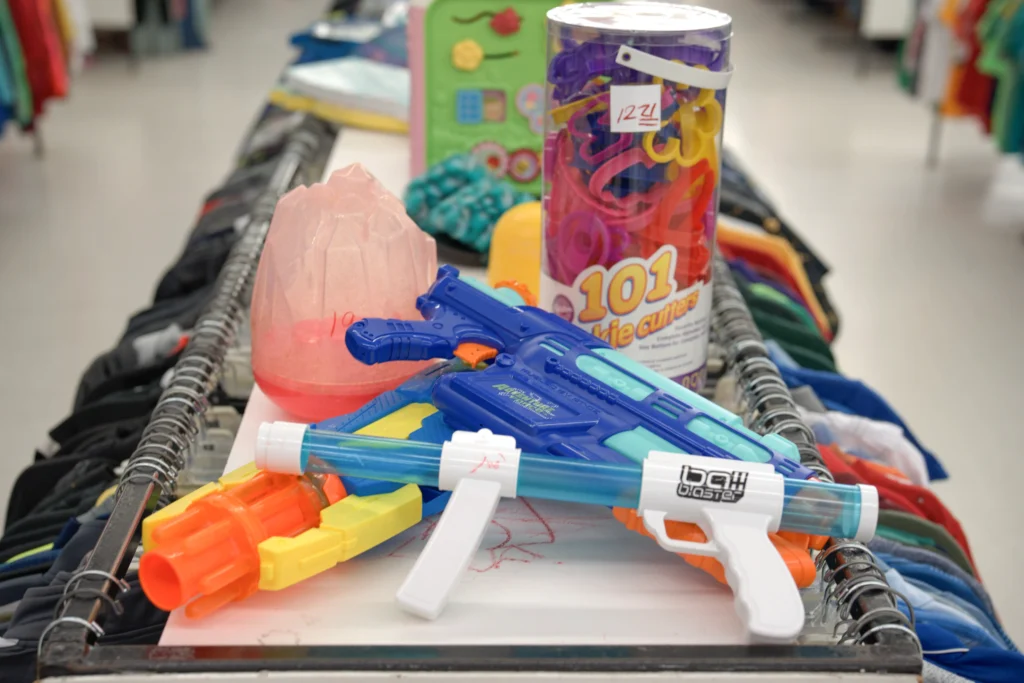Colorful children’s toys, craft supplies, and toy water blasters displayed inside Value World.