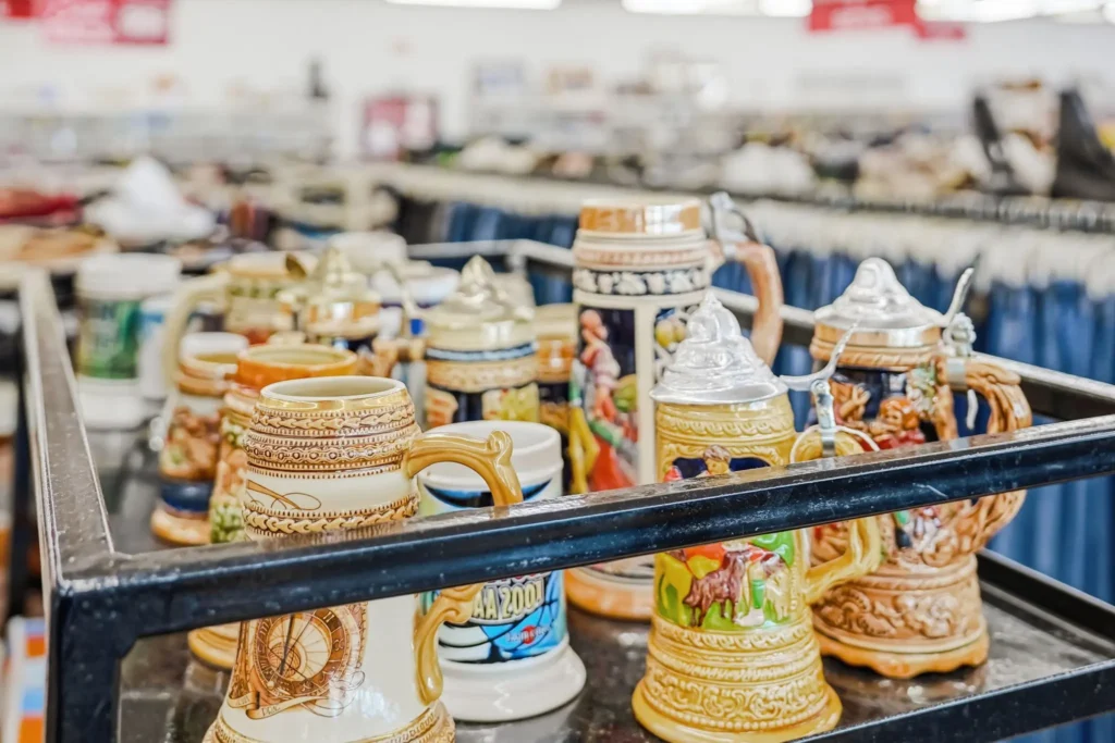 Decorative ceramic beer steins with detailed designs and lids displayed inside Value World.