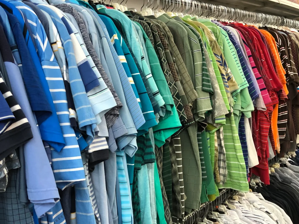 Colorful men’s polo shirts arranged by shade on a clothing rack at the North Randall Value World store.