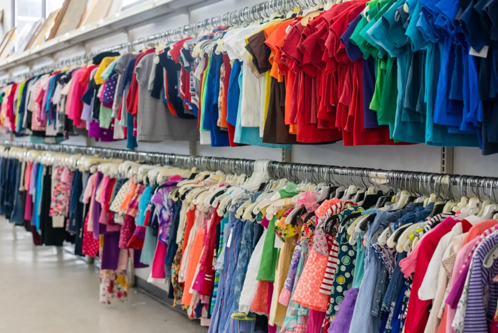 Rows of colorful children’s shirts, dresses, pants, and outfits inside Value World in Houston.