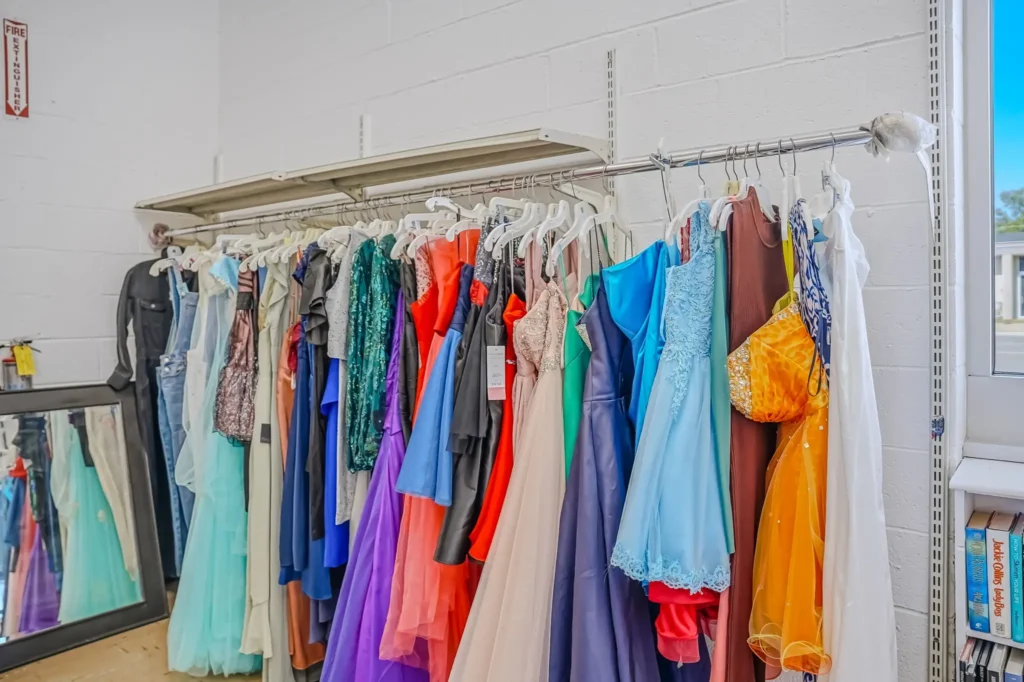 A colorful selection of formal dresses and evening gowns displayed on a clothing rack inside Value World.