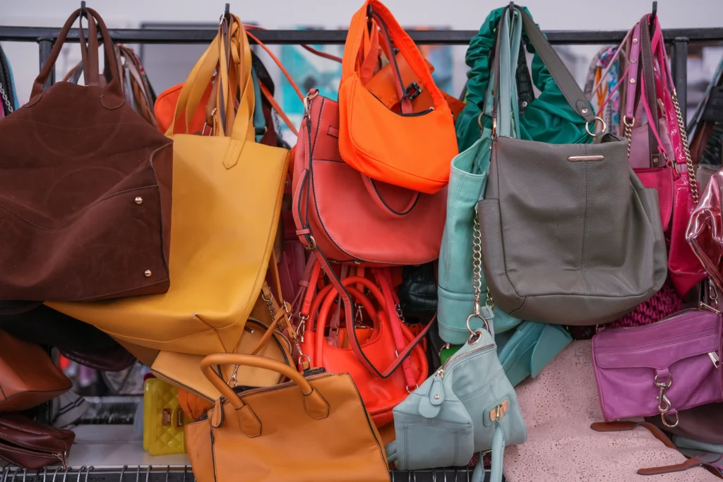 Colorful handbags, purses, totes, and shoulder bags displayed inside Value World Bissonnet in Houston.