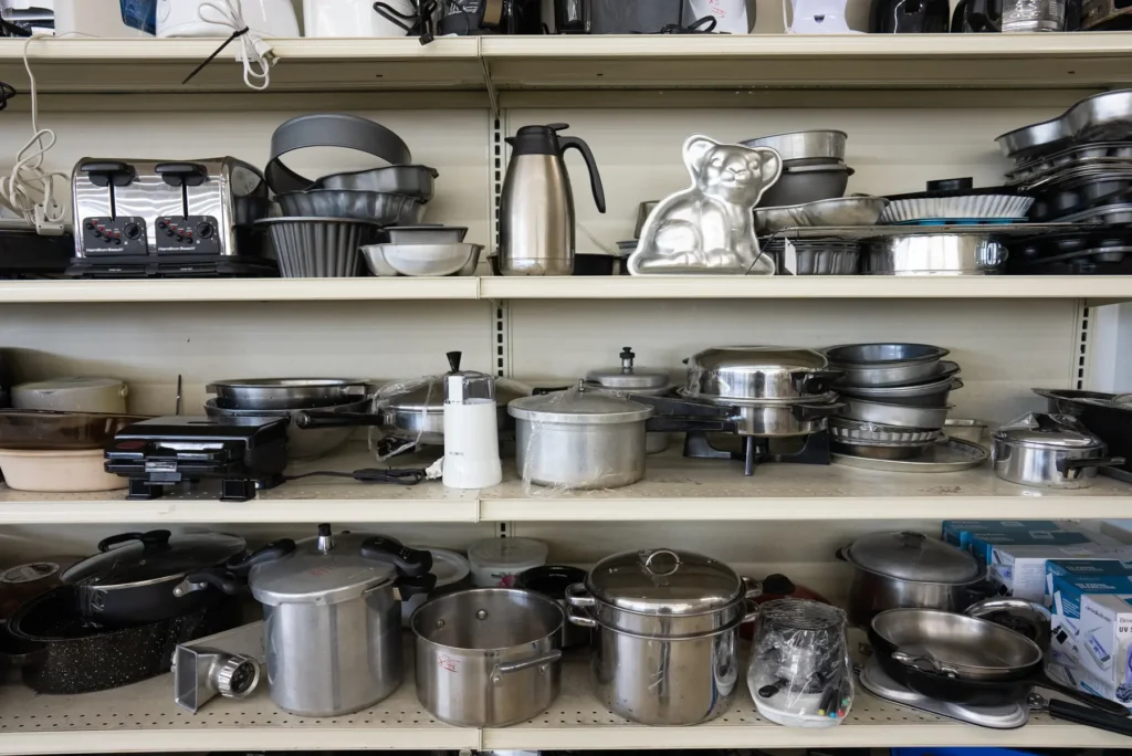 Shelves filled with pots, pans, baking dishes, and small kitchen appliances at the Value World Lakewood store.