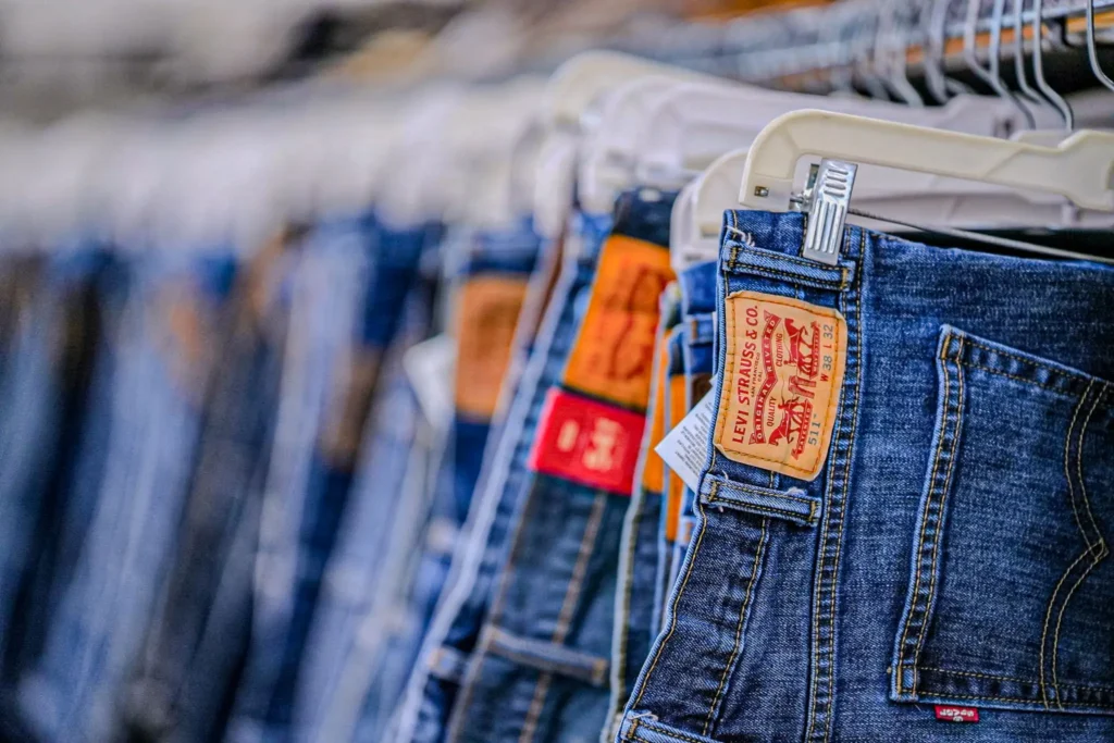 Close-up of blue denim jeans displayed on a clothing rack inside Value World in Ypsilanti.