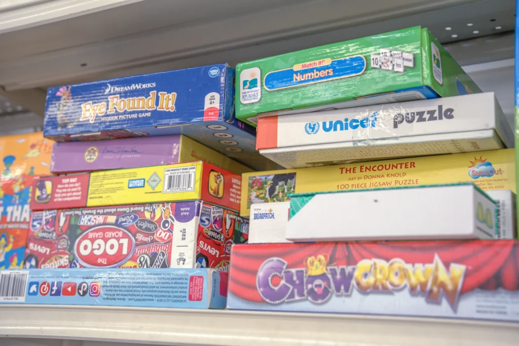 Assorted family board games, educational activities, and jigsaw puzzles displayed inside the Value World Bissonnet store.