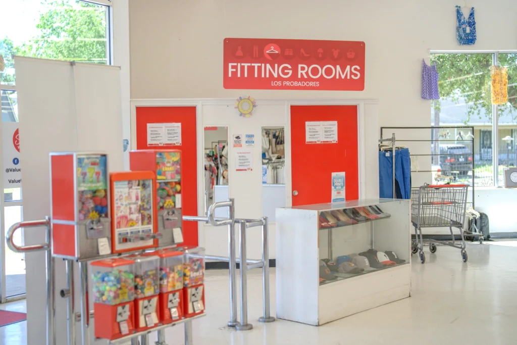 Fitting rooms near a display of hats and vending machines inside the Value World The Heights thrift store.