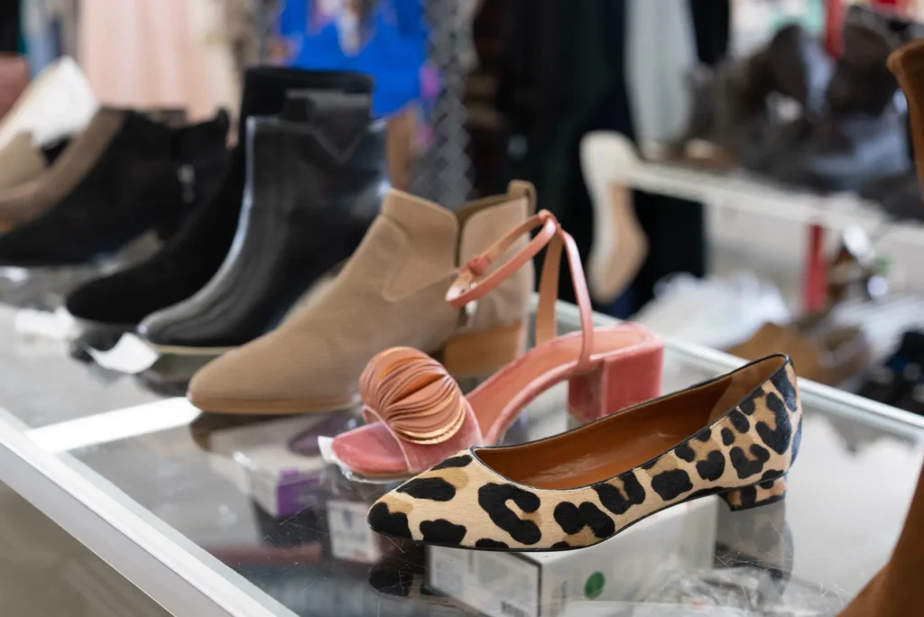 Leopard-print flats, pink heels, ankle boots, and other women’s shoes displayed at the Lakewood thrift store.
