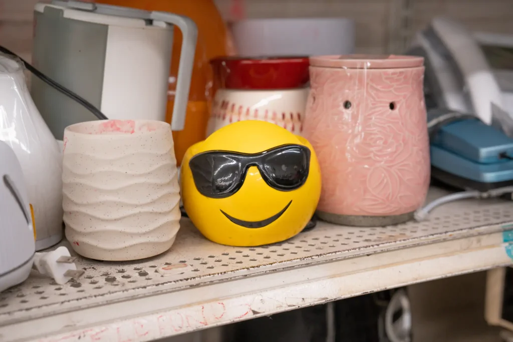 Yellow sunglasses emoji container displayed with colorful secondhand home décor at the Gessner location.