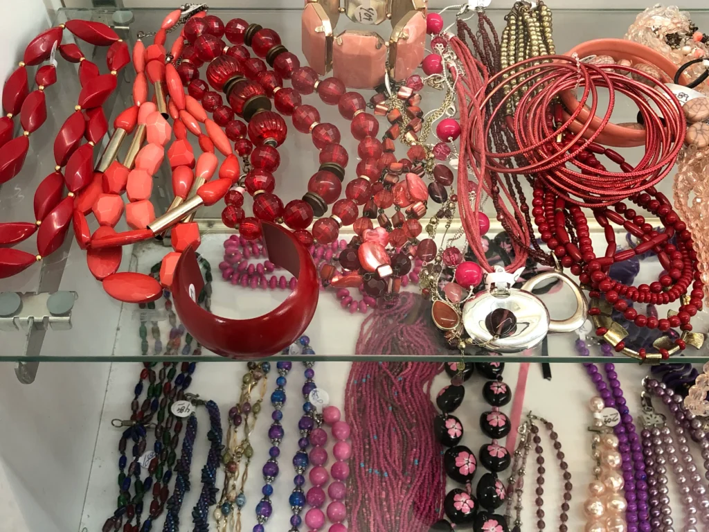 Red, pink, and purple secondhand necklaces and bracelets displayed at the Value World Harrisburg location in Houston.