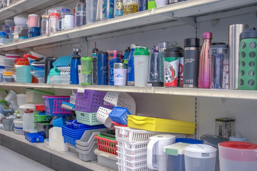 Reusable water bottles, travel mugs, food containers, and colorful storage baskets inside Value World Bissonnet.