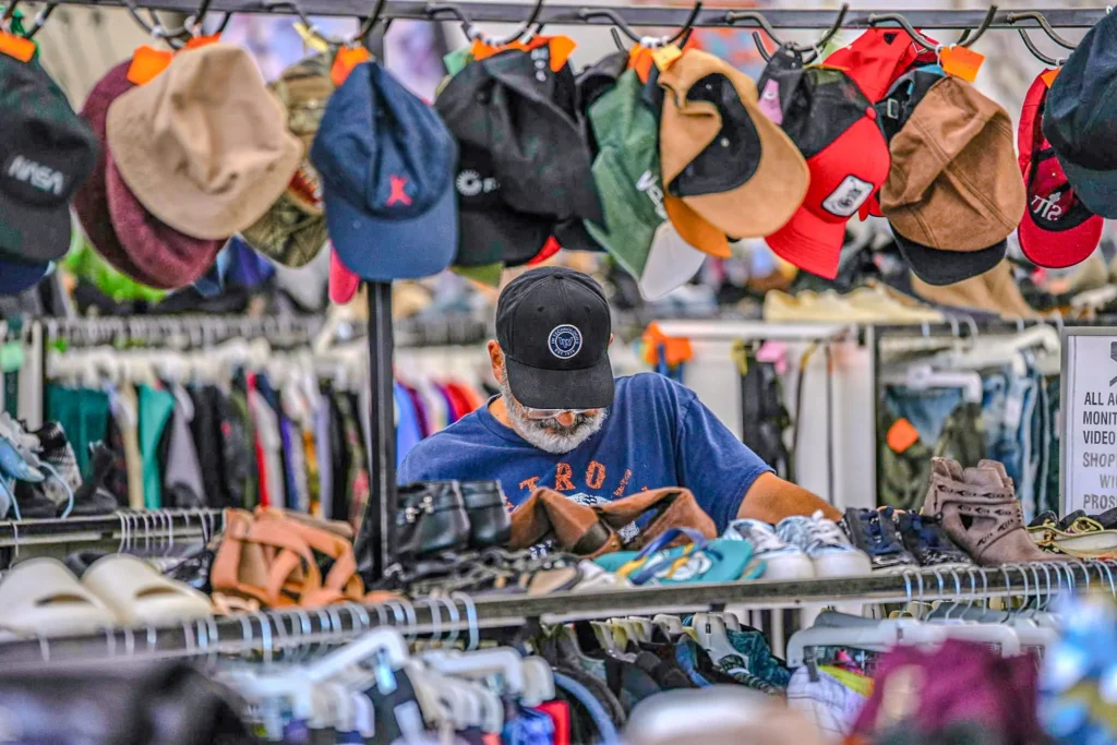 Shopper browsing among hats, shoes, and clothing inside the Value World Ypsilanti store.