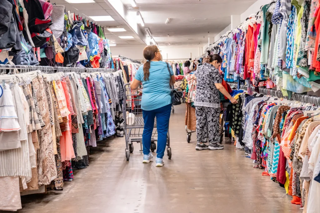Shoppers browse colorful clothing racks inside the Value World Jensen thrift store in Houston.