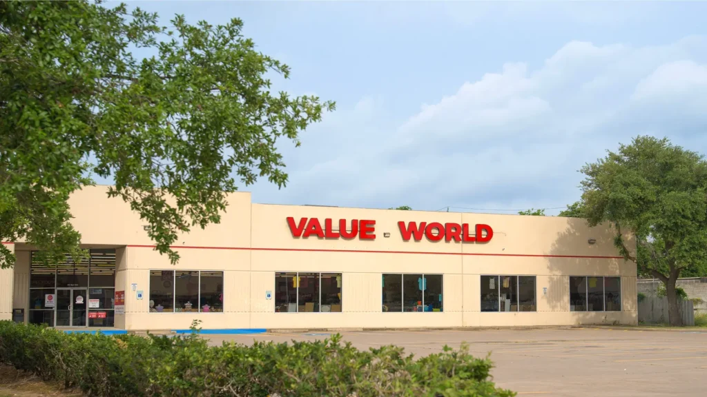 Exterior of the Value World The Heights thrift store in Houston with the entrance, storefront windows, and red signage.