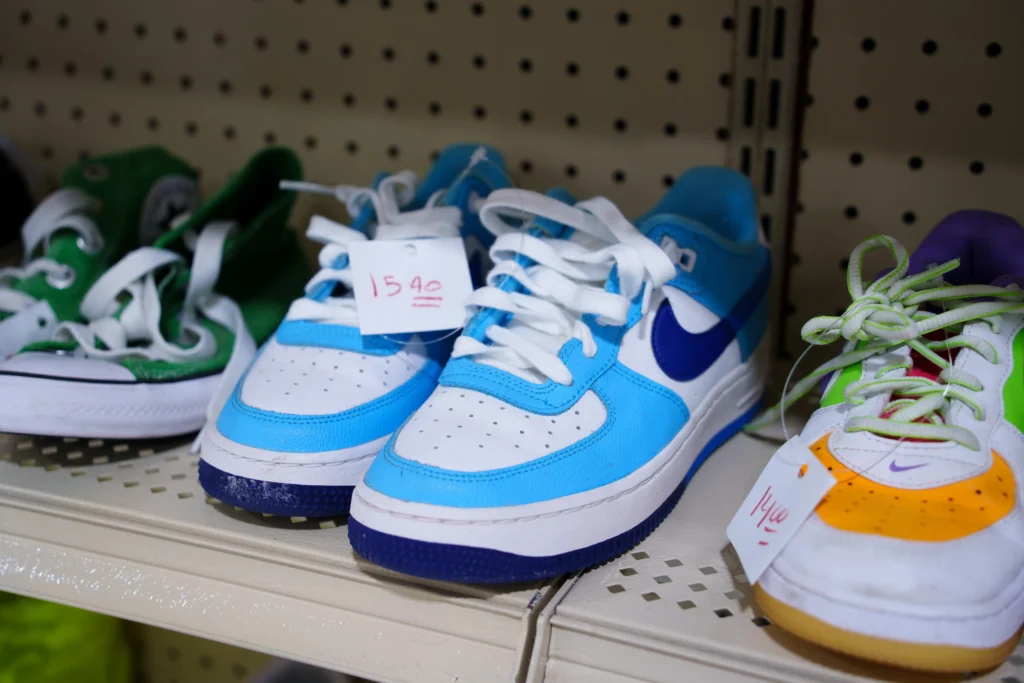 Colorful athletic sneakers displayed on a shelf inside the Value World Barker Cypress store in Houston.